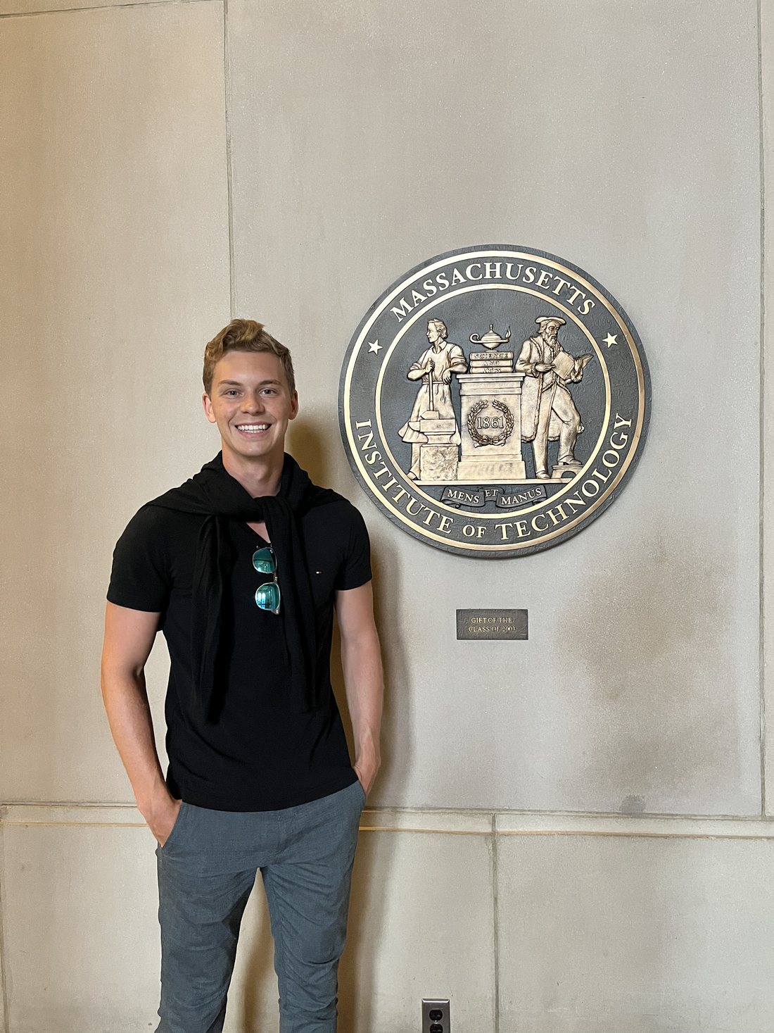 Kai beside the MIT seal in Cambridge